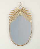 Decorative wall mirror with gold leaf design on a plain background