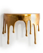 Decorative wall shelf with gold metallic finish and dripping effect on a white background