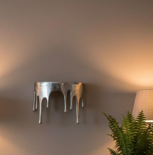 Decorative wall sconce with a plant and lamp in the background
