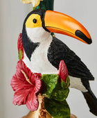 Carved toucan figurine with a colorful flower on a plain background