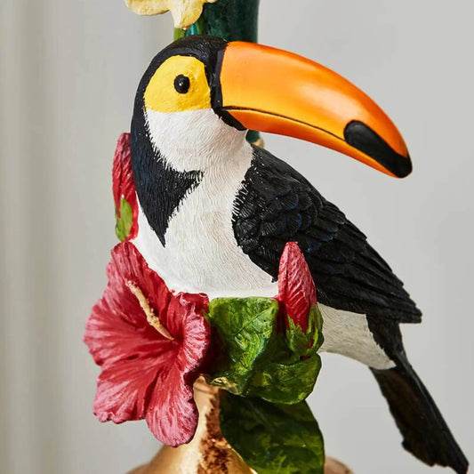 Carved toucan figurine with a colorful flower on a plain background