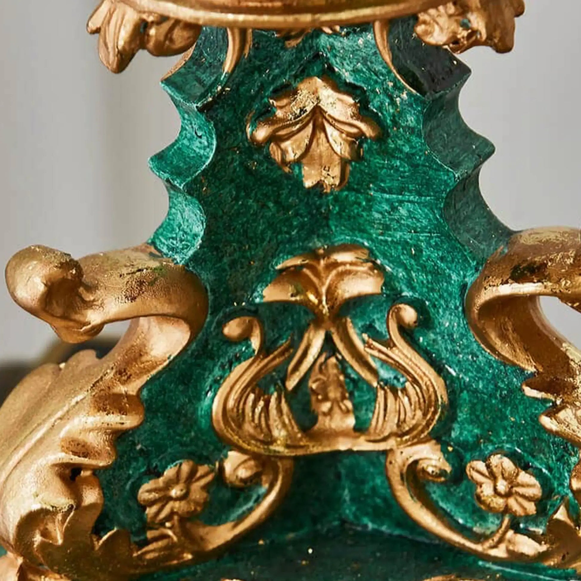 Decorative object with gold and green intricate design on a gray background