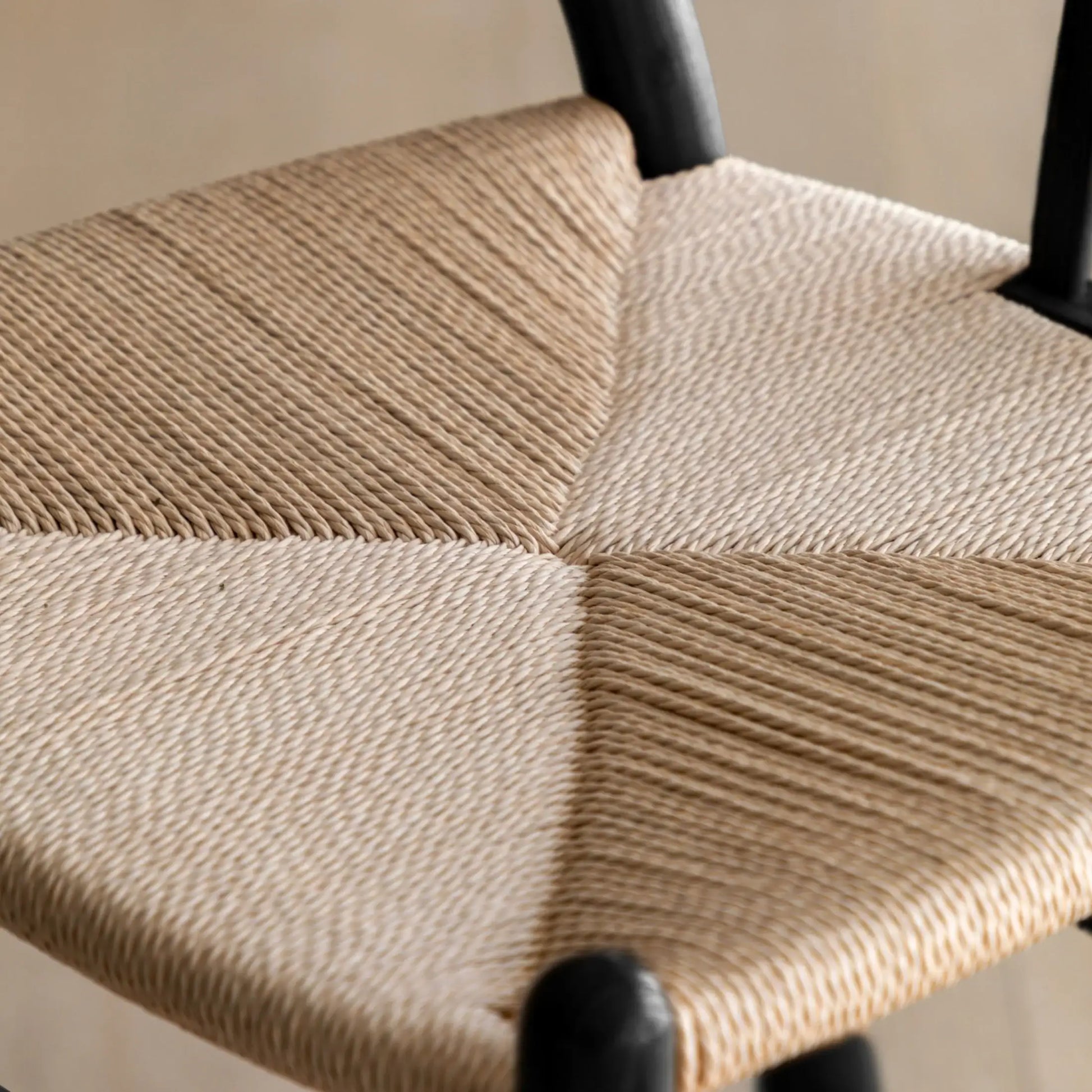 Close-up of a woven chair seat with a neutral color palette.