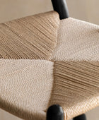 Close-up of a woven chair seat with a neutral color palette.