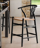 Black bar stools with woven seats in a kitchen setting