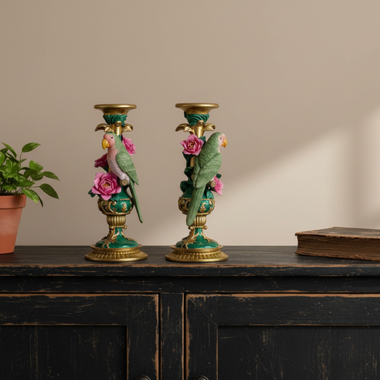 Decorative candle holders with birds and flowers on a wooden surface.