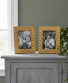 Two yellow textured picture frames on a gray cabinet with a plant in the background.
