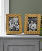 Two textured gold picture frames on a gray surface with photos inside.