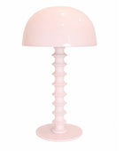 Pink table lamp with a ribbed base on a white background