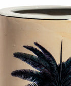 Ceramic planter with palm leaf design on a beige background