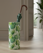 Tall cylindrical vase with green leaf pattern on a wooden floor