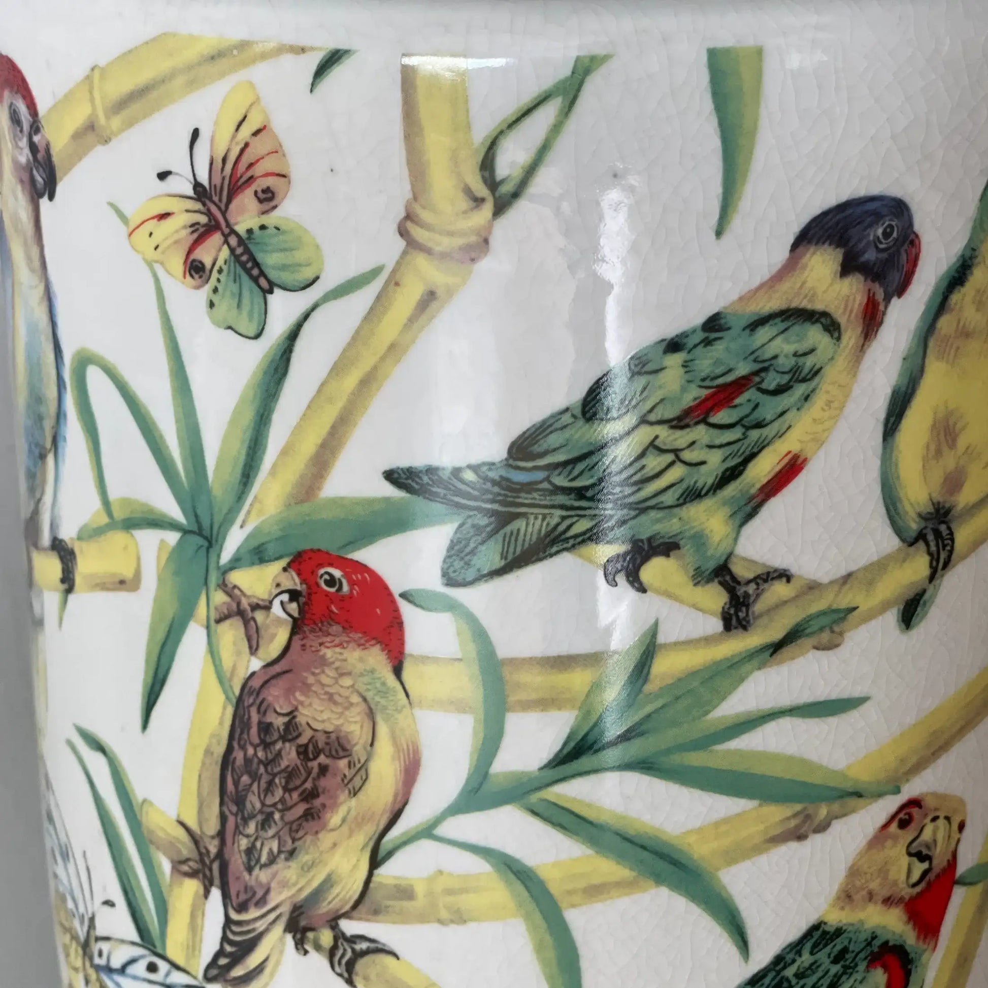 Decorative tile with parrot and butterfly design on a white background