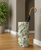 Umbrella stand with bird design next to a plant indoors