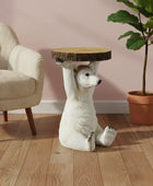 Decorative side table shaped like a bear holding a wooden platform in a room with a chair and plant.