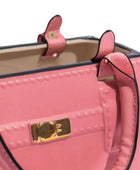 Close-up of a pink handbag with a gold clasp on a white background