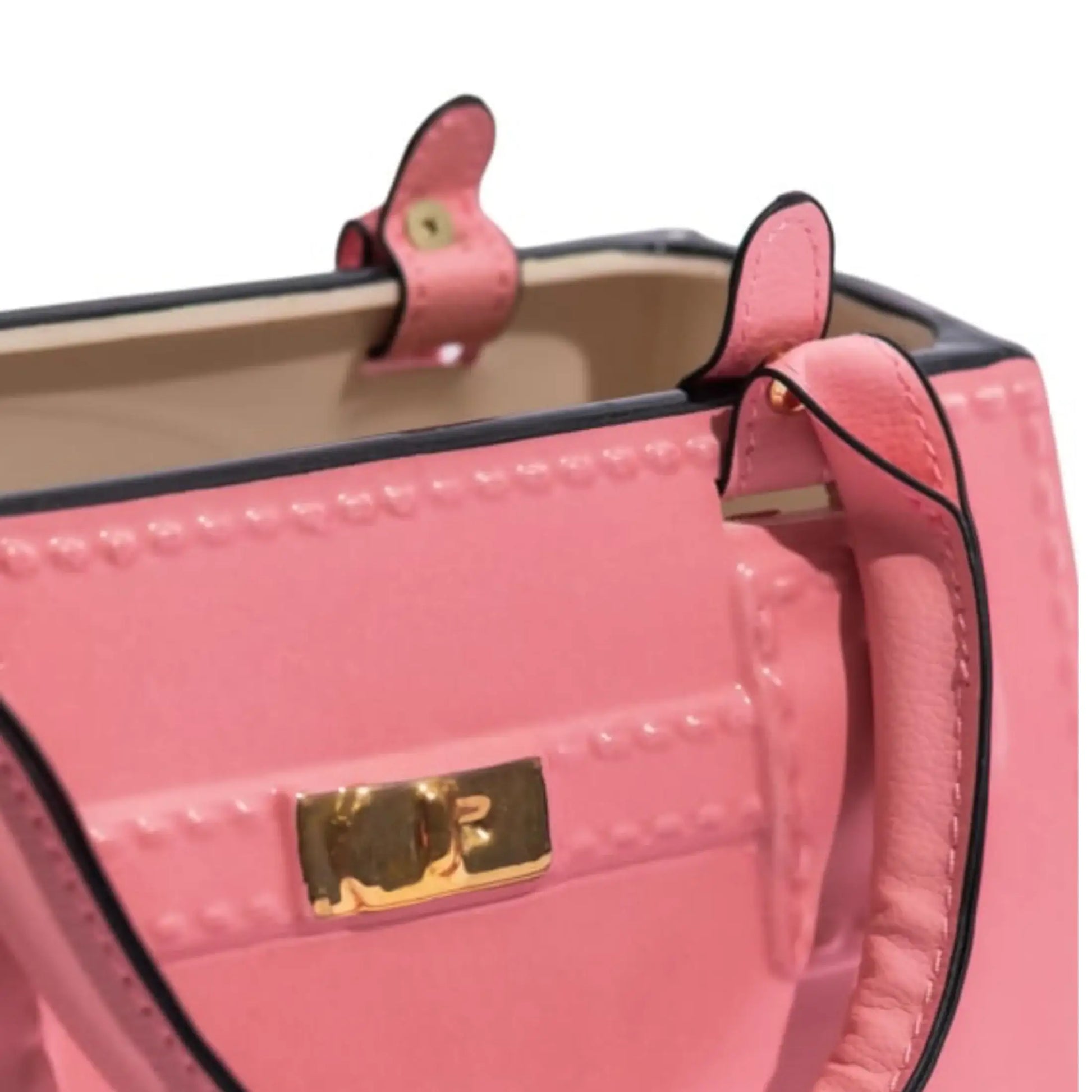 Close-up of a pink handbag with a gold clasp on a white background