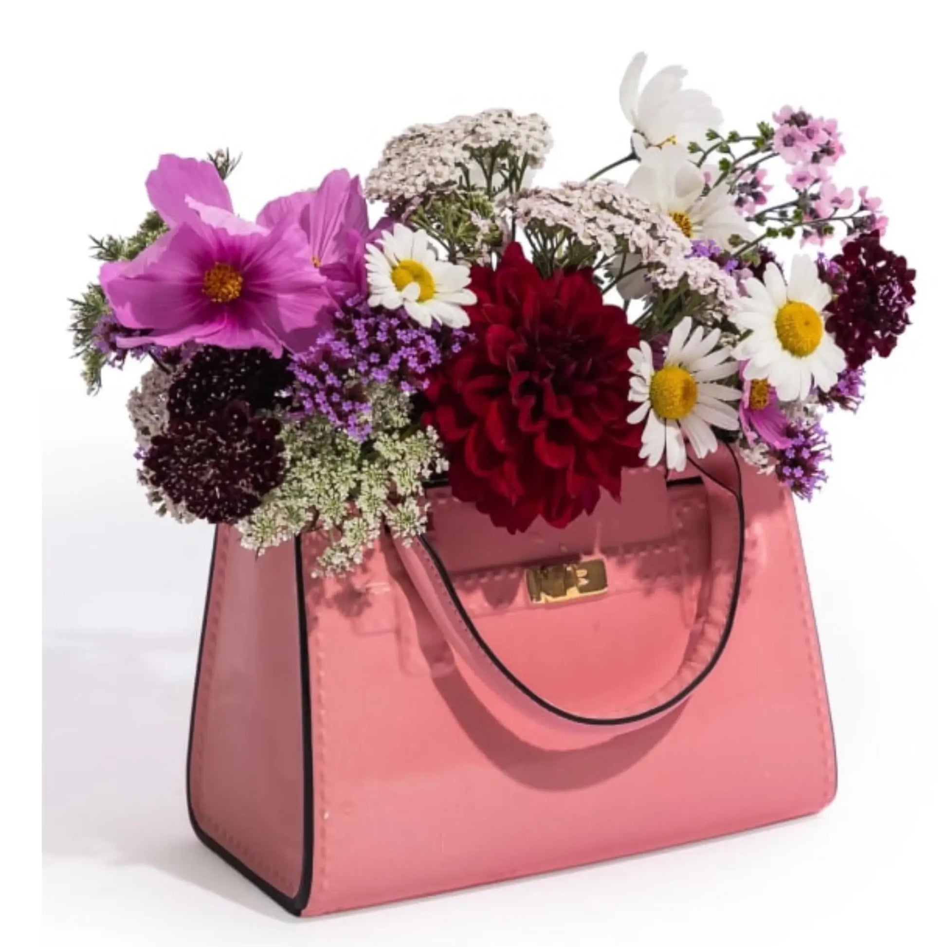 Pink handbag filled with a colorful bouquet of flowers on a white background