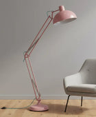 Pink floor lamp and gray chair against a plain wall.
