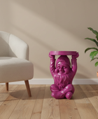 Purple gnome-shaped side table in a room with a beige chair and plant.