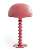 Pink table lamp with a unique base design on a white background
