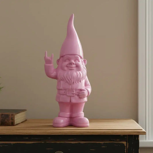 Pink gnome figurine on a wooden surface with a plain wall background