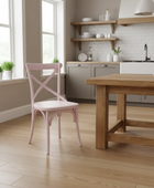 Modern kitchen with wooden table and pink chair, light wood flooring and neutral walls.