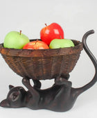 Decorative cat-shaped fruit bowl with apples on a white background