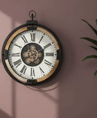 Decorative wall clock with Roman numerals on a pink wall