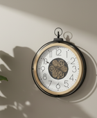 Decorative wall clock with gear design on a beige wall