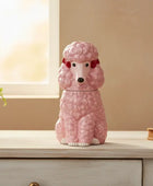 Pink poodle-shaped cookie jar on a wooden surface with a neutral background