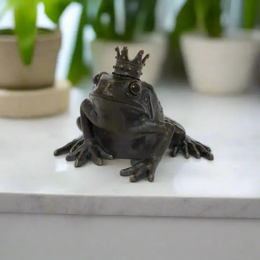 Bronze frog figurine with a crown on a white background