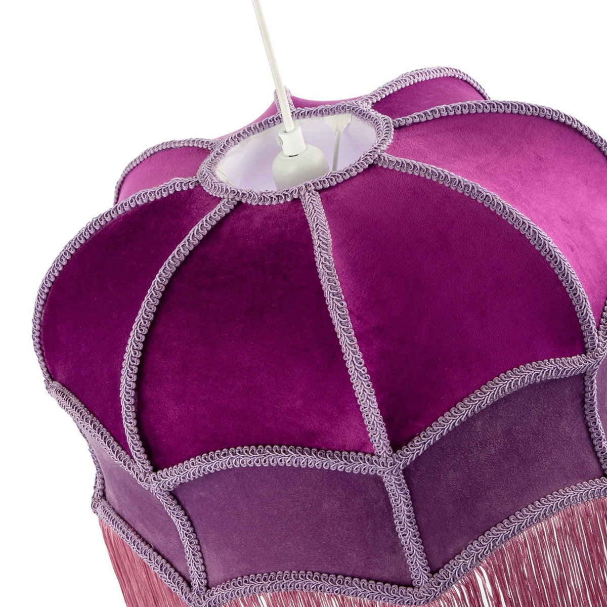 A close-up of a purple fabric chandelier shade with scalloped panels, decorative silver-gray fringe trim, and pink fringe hanging from the bottom, shown against a white background.