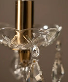 Close-up of a decorative crystal holder with hanging crystal pendants against a dark background.