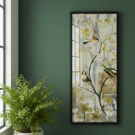 Framed artwork of birds on branches with flowers on a green wall next to a potted plant.