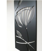 Decorative metal wall art with floral design on a black background