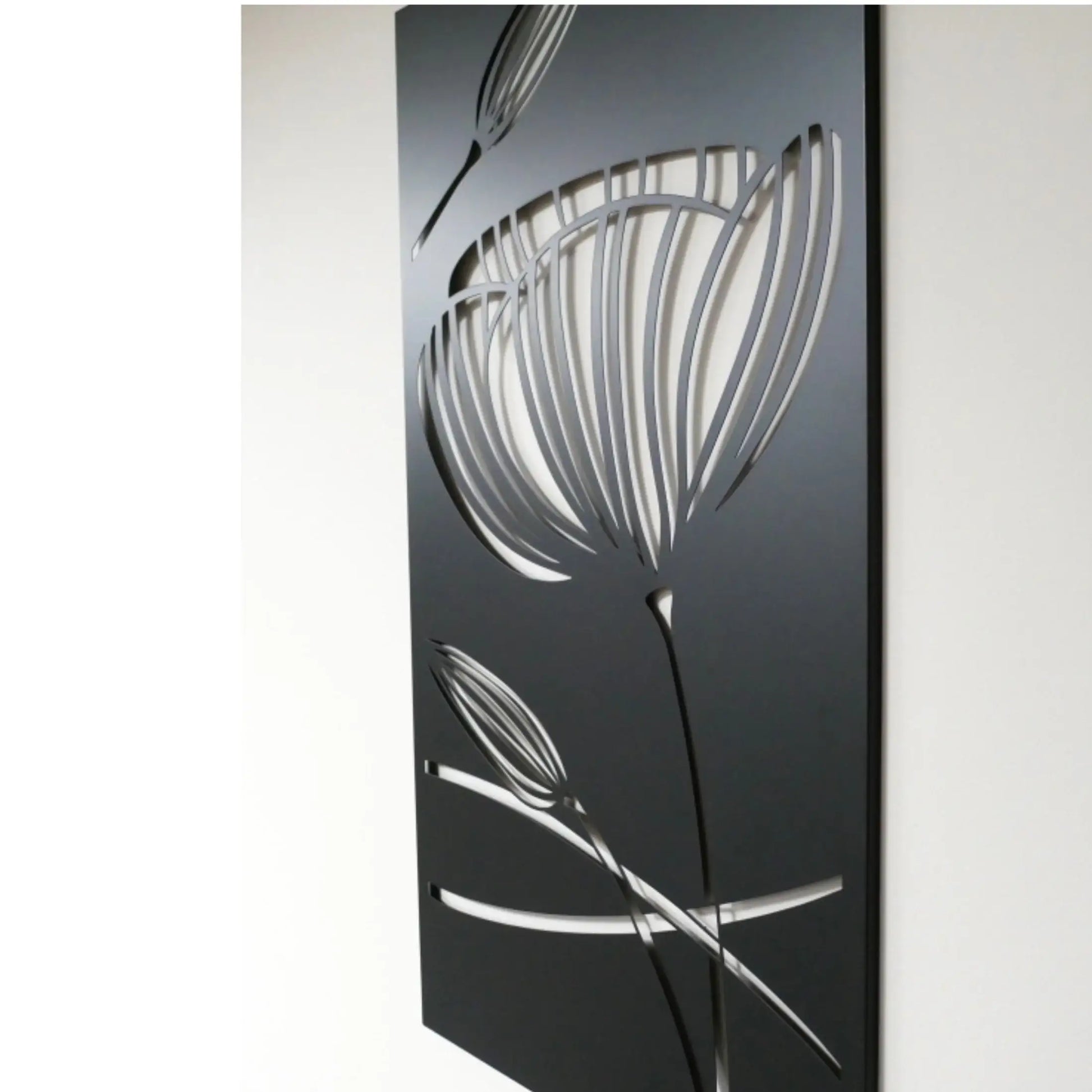 Decorative metal wall art with floral design on a black background