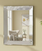 Rectangular mirror on a beige wall with a chair and plant in the reflection