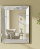Rectangular mirror on a beige wall reflecting a living room with a chair and plant.