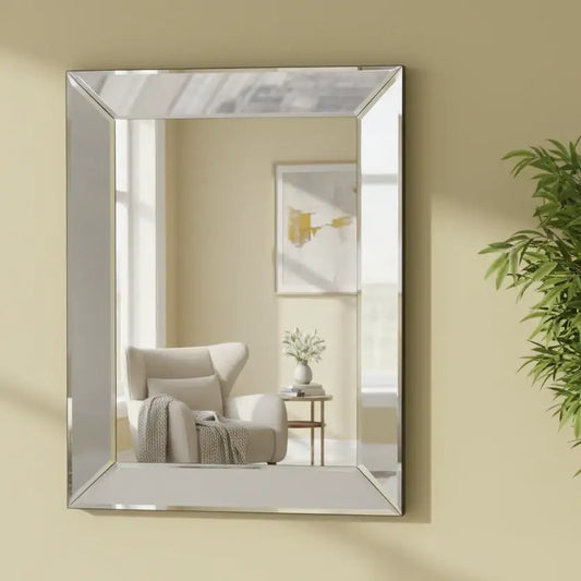Rectangular mirror on a beige wall reflecting a living room with a chair and plant.
