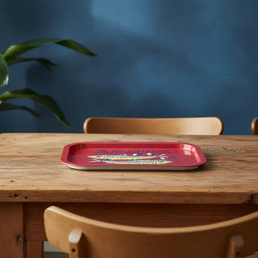 Red tray with colorful design on a wooden table against a blue wall