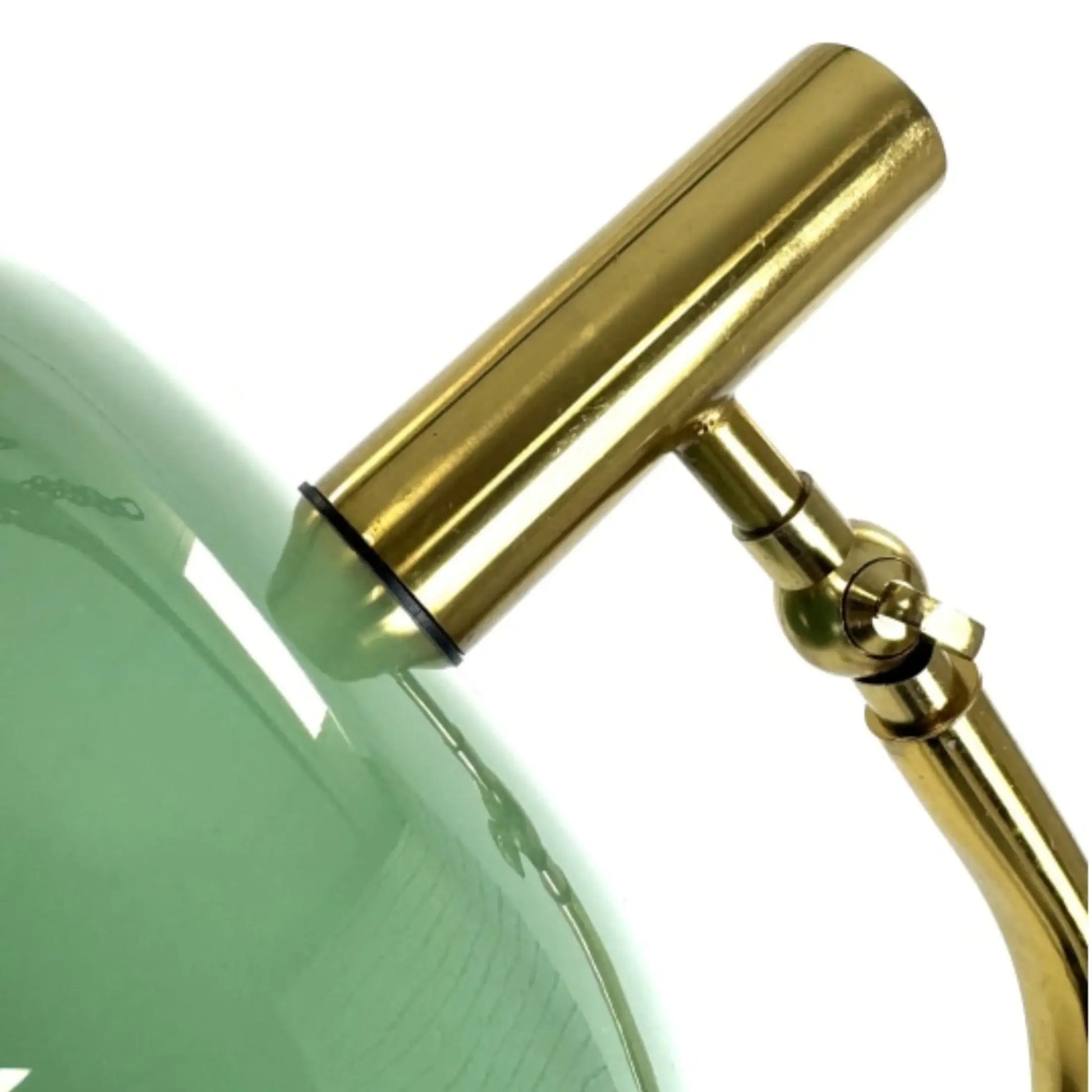 Close-up of a green glass object with a gold metal handle on a white background