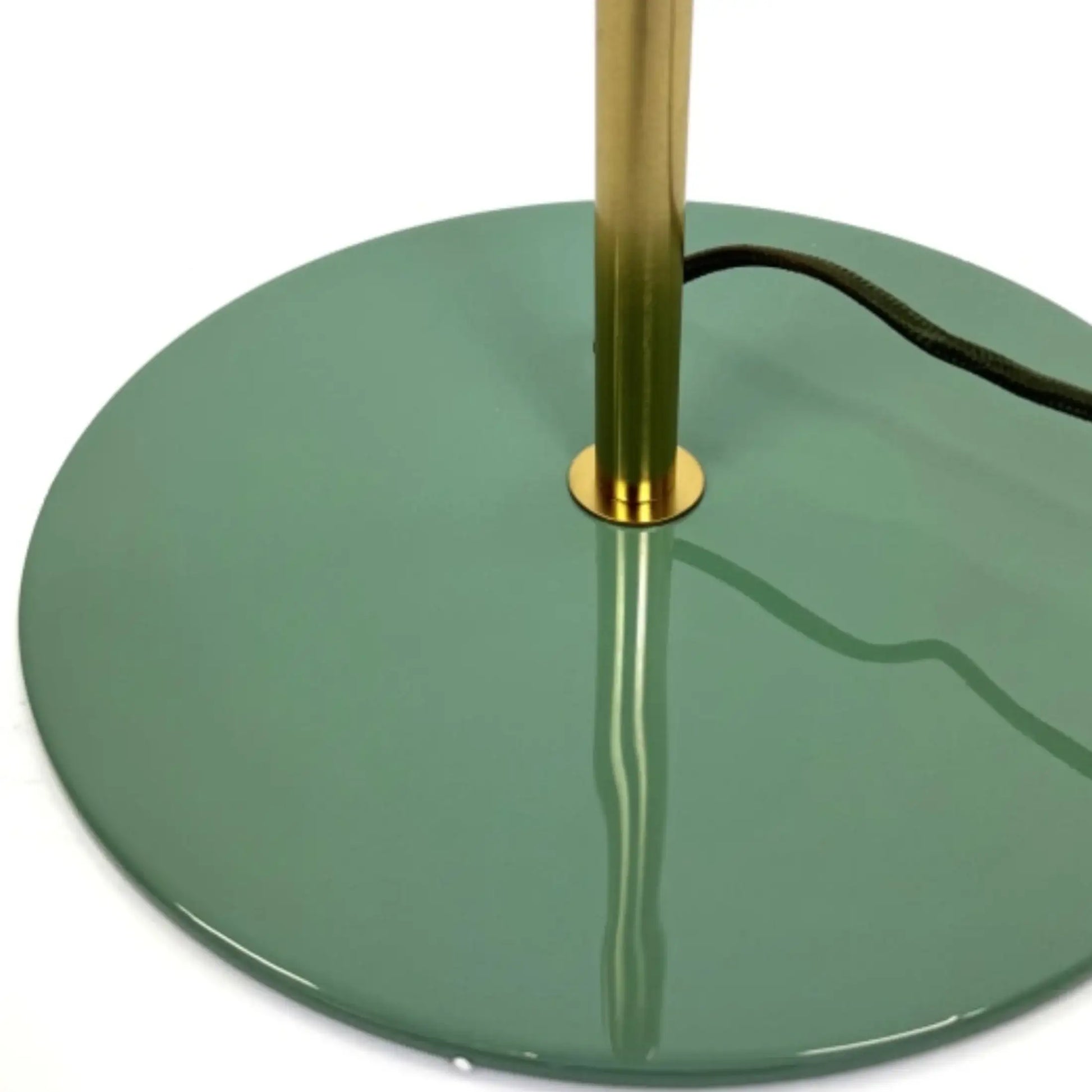 Green floor lamp with gold base on a white background
