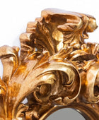 Close-up of an ornate gold decorative piece with intricate leaf and scroll designs.