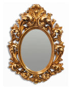 Decorative gold mirror with intricate patterns on a white background