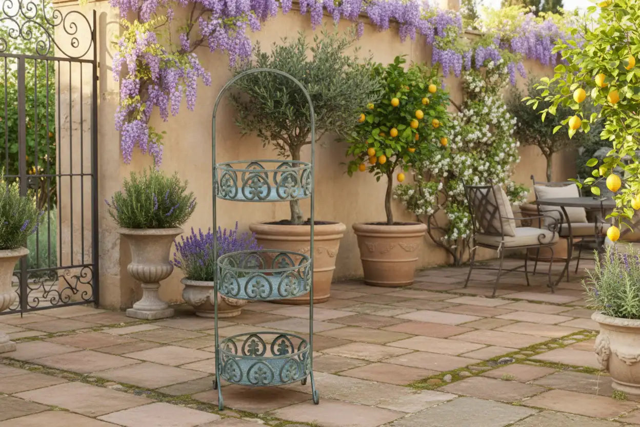 Decorative metal plant stand in a garden setting with potted plants and flowers.