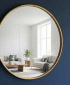 Round gold-framed mirror on a wall with a blurred indoor background