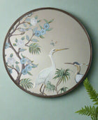 Decorative mirror with bird and floral design on a white background