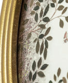 Close-up of a decorative item with a gold frame and leaf pattern.