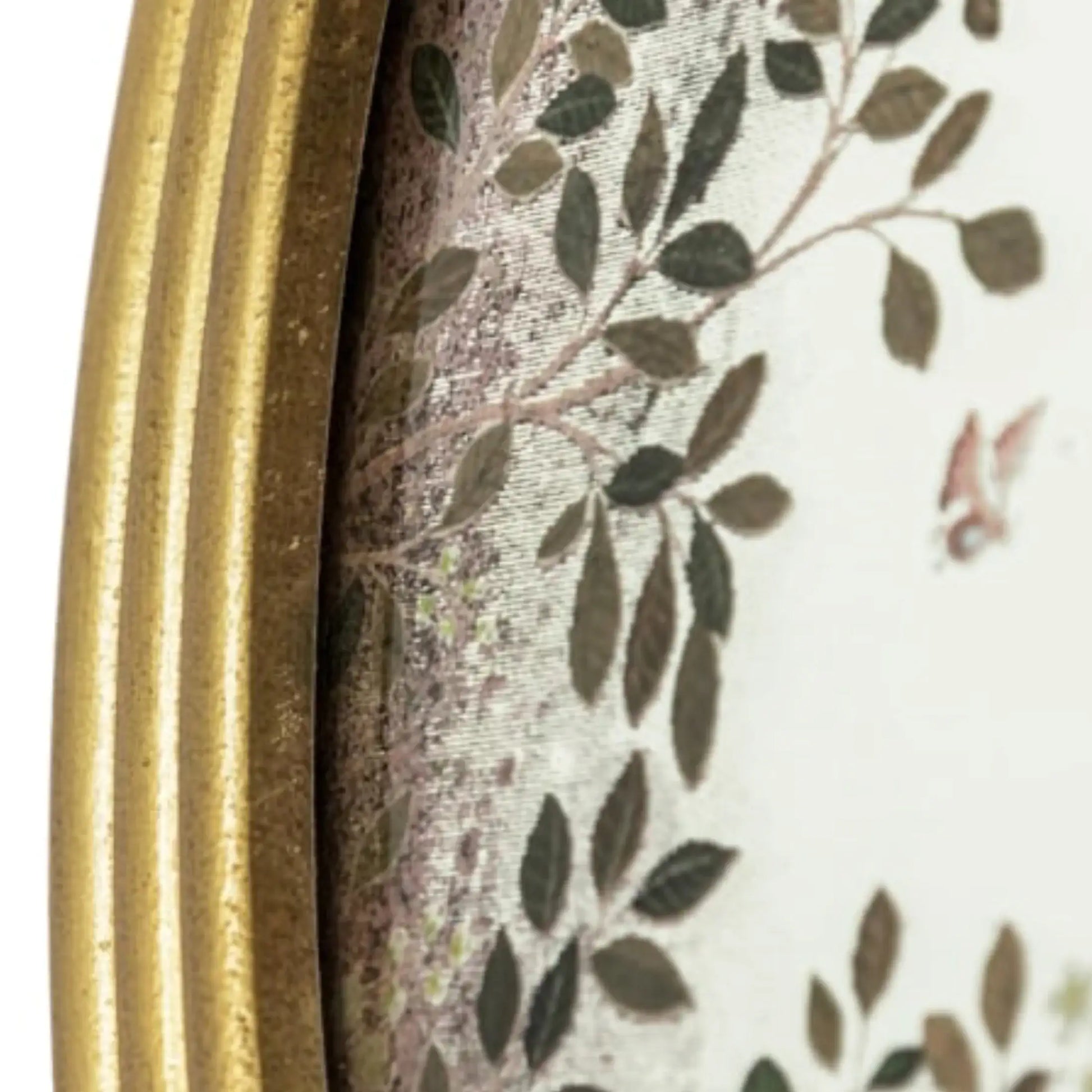 Close-up of a decorative item with a gold frame and leaf pattern.