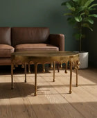 Gold coffee table in a living room with a brown sofa and a plant.